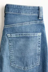 Jean de cinco bolsillos en denim de algodón con stretch. Modelo bootcut de tiro alto, ajustado de cintura a cadera y con corte ligeramente acampanado desde la rodilla hacia el bajo. Presenta raya marcada en la parte delantera y trasera.