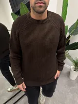 Sweater de punto marrón con cuello redondo y mangas raglán.
