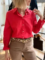 Camisa rojo ciruela de manga larga, con botones de nácar en la parte frontal y en los puños, cuello clásico y sutiles rayas verticales en la textura del tejido.