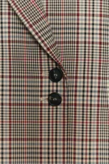 Blazer de cuello solapa y manga larga con diseño de cuadros. Presenta cierre frontal cruzado con botones.