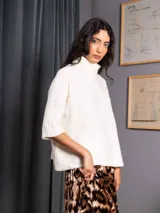 Poleron negro de tejido de punto con cuello alto doble y mangas 3/4 con puños acanalados.