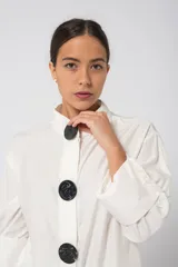 Camisola fucsia con cuello mao, mangas largas con puños y cierre frontal con botones grandes negros.