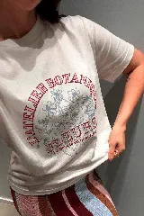 Remera básica de manga corta color crudo con estampa frontal circular que incluye flores en tonos celestes y la inscripción en color bordó "L'Atelier Botanique Fleurs La beauté de la nature".