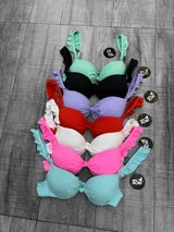 Corpiño de bikini con aro y relleno, color celeste, con detalle de nudo central y tirantes anchos con volados.