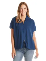 Cardigan de punto azul, con cierre frontal metálico completo, cuello con solapa y mangas cortas de sisa caída. Presenta un corte recto y holgado.