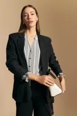 Camisa de manga larga con silueta relajada, estampado a rayas verticales en blanco y gris, escote abierto con botones frontales y puños elastizados.