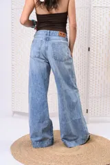 Pantalón wide leg de denim con lavado celeste vintage, tiro medio y dobladillo ancho marcado en las botamangas.