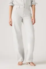 Pantalón de jean estilo baggy con corte barrel, tiro alto y pierna ancha. Presenta un tono gris claro lavado, con costuras reforzadas y diseño de cinco bolsillos.