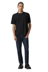 Pantalón de jean corte slim taper, con ajuste entallado en el muslo y pierna que se estrecha hacia el tobillo. Presenta un lavado azul oscuro clásico con costuras en contraste y cierre frontal con botón y cremallera.