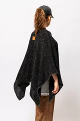 Ruana negra con lurex dorado, de corte cuadrado y mangas 3/4.