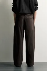 Pantalón barrel fit de corte ancho color marrón, confeccionado en mezcla de algodón y lino. Presenta bolsillos frontales, bolsillos traseros de vivo y cierre frontal con cremallera y botón.