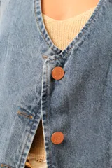 Chaleco color crema con botones, sin mangas y cuello en V.