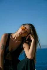 Top negro de lino con escote en V y tiras para atar en el centro.