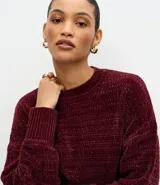 Suéter de punto chenille color gris oscuro, con cuello redondo alto, textura acanalada y puños ajustados.