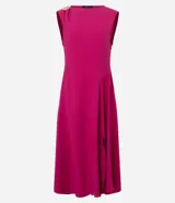 Vestido midi de sastrería color fucsia, sin mangas y con escote redondo. Presenta un adorno metálico dorado en uno de los hombros y una abertura lateral en la falda que aporta movimiento.