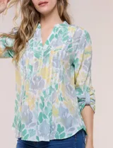 Blusa de gasa de la marca Zac & Rachel, con estampado de rayas verticales en tonos azules, celestes y lilas. Presenta cuello a la base con escote en V, abertura central con botones, detalle plisado en el frente y mangas de largo regulable con presilla y botón.