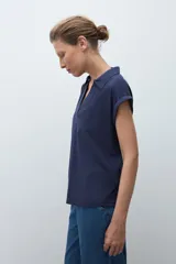 Remera azul marino de manga corta con cuello polo y escote en V con cierre.