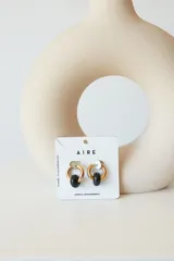 Aros dorados con dije circular de piedra natural negra.