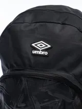 Mochila Umbro de color gris oscuro con diseño estampado en el bolsillo frontal. Cuenta con compartimento principal con cierre, bolsillo frontal con cierre, bolsillos laterales de red y logo de la marca aplicado en la parte superior.