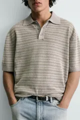 Polo relaxed fit de punto tejido en hilatura con mezcla de algodón y textura rizada, color gris con diseño a rayas sutiles, cuello solapa con cierre frontal de botonadura y manga corta con acabados en rib.