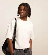 Remera masculina blanca de corte relajado, cuello redondo y manga corta. Confeccionada en malla de algodón 100% sostenible.