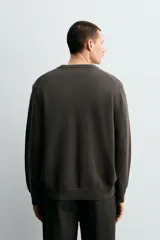 Jersey de punto con cuello redondo y manga larga, de corte regular fit con terminaciones en rib.