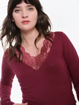 Remera de dormir entallada de viscosa, color bordó, con escote en V profundo adornado con encaje al tono y mangas largas.
