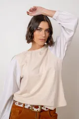 Remera de algodón color azul marino, con cuello redondo fruncido y mangas largas abullonadas con puños elásticos.