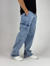 Pantalón de jean celeste con lavado ácido, corte ancho (baggy) y múltiples bolsillos cargo.