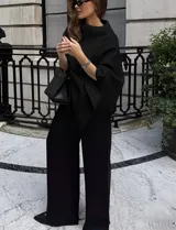 Chal tipo capa color negro, con diseño amplio y asimétrico, de textura suave y estructurada.