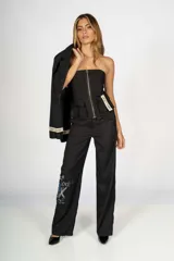 Top negro tipo corset, sin mangas, con cierre frontal metálico, bolsillos tipo cargo y etiqueta con la inscripción "Craft Punk" en el lateral.