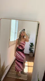 Conjunto de dos piezas compuesto por un top strapless y una falda midi con tajo lateral, ambos confeccionados en tejido elástico con estampado de ondas en tonos rosados, fucsias y violetas.