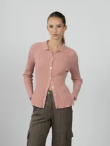 Camisa de punto acanalado en color rosado, con cuello polo y cierre frontal de botones. Presenta mangas largas y un ajuste entallado al cuerpo.