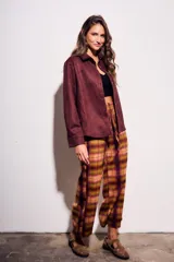 Pantalón de tiro medio y calce recto, confeccionado en poliéster con estampado de cuadros escoceses en tonos burdeos, mostaza, verde oliva y rosado.