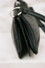 Bolso de hombro de diseño alargado y estructura rígida, confeccionado en material con acabado efecto cuero envejecido. Cuenta con asa corta ajustable mediante herrajes metálicos dorados, cierre principal de cremallera y compartimentos internos.