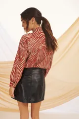 Camisa de manga larga color crudo con estampado floral, cuello con lazo y corte holgado.