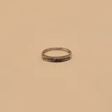 Anillo de diseño entrelazado con acabado bicolor, combinando oro amarillo y oro blanco con incrustaciones de circonias.