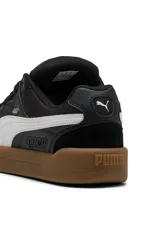 Championes Puma modelo Park Lifestyle Sk8, de diseño urbano inspirados en el skate, color blanco con franja lateral negra, detalles en gamuza gris en la puntera y suela de goma marrón tipo gum.