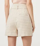 Short de tiro alto confeccionado en tejido tweed con estampado pied-de-poule. Presenta una cinturilla ancha con trabillas y un corte estructurado de estilo sastrero.