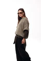 Sweater de tejido de punto grueso con silueta amplia y mangas 3/4. Presenta un diseño de calce relajado con cuello redondo y textura voluminosa.