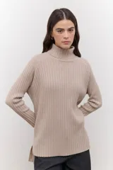 Polera de punto acanalado en color beige, con cuello alto, mangas largas y diseño de largo irregular con aberturas laterales.