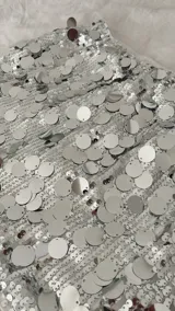 Minifalda plateada con lentejuelas circulares, tiro bajo y cintura elástica.