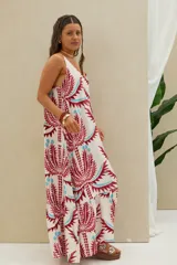 Vestido largo de tirantes en color blanco con estampado geométrico y floral en tonos bordó y celeste, corte amplio y volados en el ruedo.