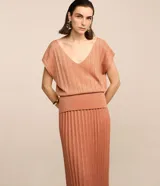 Pollera midi recta color ladrillo, de viscosa plisada con hilo metalizado y elástico en la cintura.