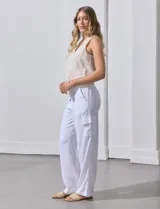 Pantalón de lino color blanco, de corte recto y tiro alto. Presenta bolsillos laterales tipo cargo y pretina elastizada en la parte trasera.