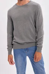 Buzo de punto con cuello redondo, manga larga y puños acanalados, de diseño clásico y ajuste estándar.