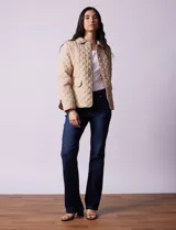 Campera capitoneada color beige, marca Weatherproof, con cuello con solapa, abertura central con botones metálicos, bolsillos delanteros y forro interno a tono.