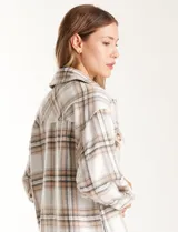 Sobrecamisa larga de tejido soft con estampado de cuadros en tonos celestes, beige y blanco. Presenta cuello con solapa, cierre frontal con botones, bolsillos aplicados en el pecho y mangas largas con puños abotonados.