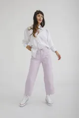 Pantalón de jean color amarillo pastel, de corte recto y tiro medio, con diseño de cinco bolsillos y cierre frontal con botón y cremallera.