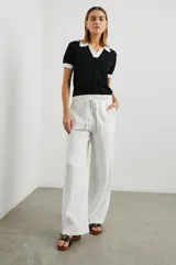 Remera negra de punto con cuello polo y ribetes blancos en cuello y mangas.